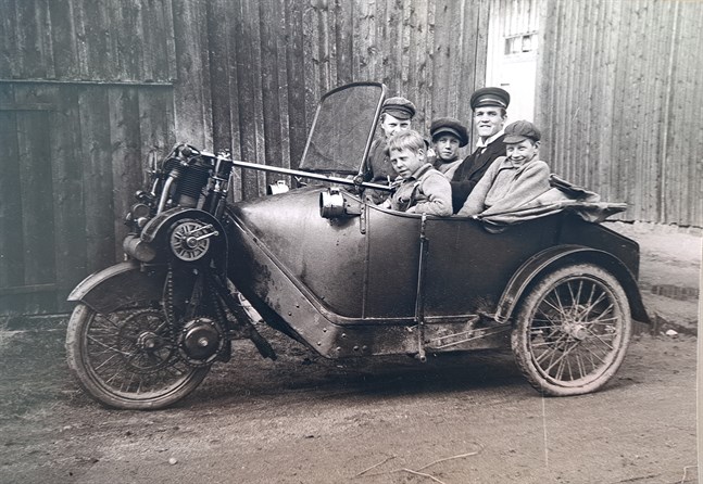 Viktor Myhrmans trehjuliga phänomobil 1912? En stolt ägare och fyra glada pojkar. Men, vilka är de? Vet någon? Framhjulsdrivet ekipage med sparkstyrning. Tvåcylindrig fyrtaktsmotor med kedjedrift och fläktkylning av de öppna cylindrarna. Gasbelysning. Kan ej ha varit lätt att framföra på den tidens "hästvägar". Bilen gjorde ju tre hjulspår! Notera den utanpåliggande handbromsspaken.