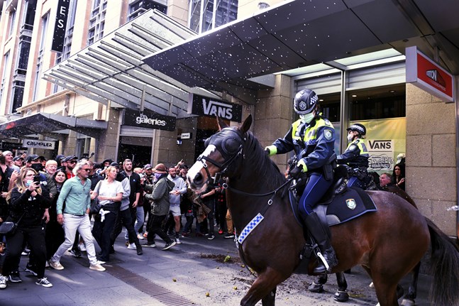 Polis i Sydney försöker hindra demonstranternas framfart.