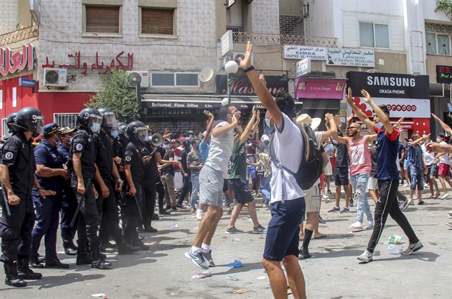 Demonstranter drabbar samman med polis i Tunisiens huvudstad Tunis under söndagen. Våldsamma demonstrationer har brutit ut på flera håll i landet i protest mot landets styre.