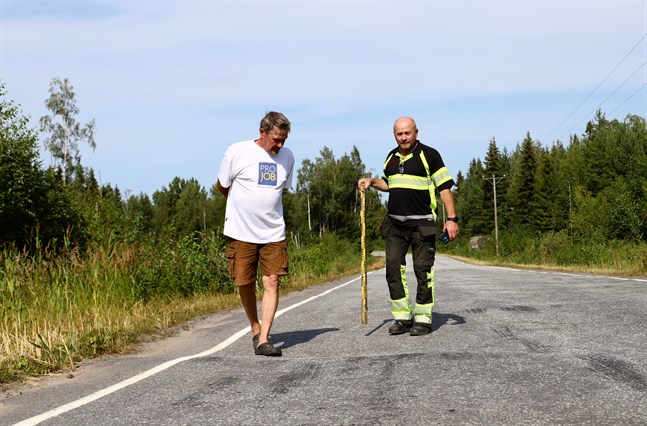 Henrik Backlund och Göran Burman står vid gropen som sträcker sig över körfältet.