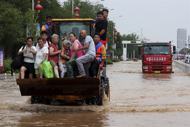 Människor räddas undan översvämningarna i Henan i Kina.