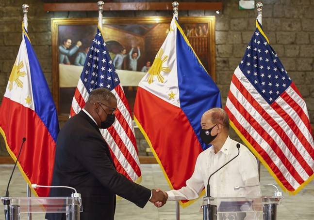 USA:s försvarsminister Lloyd Austin skakar hand med Filippinernas försvarsminister Delfin Lorenzana efter deras möte i Manila.