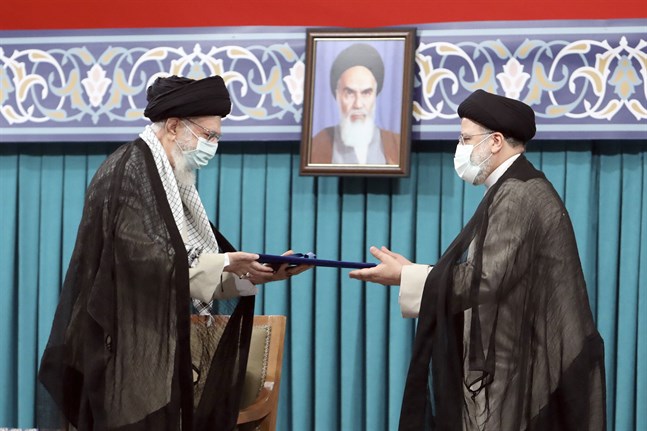 Irans högsta ledare Ayatollah Ali Khamenei (till vänster) ger sitt officiella godkännande till landets nya president Ebrahim Raisi vid en ceremoni i huvudstaden Teheran.