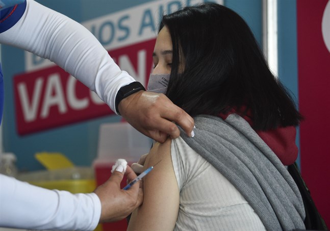 En ung kvinna i Argentina får en dos vaccin som donerats av USA.