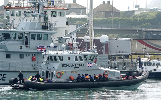 En grupp migranter förs in till hamn av den brittiska kustbevakningen. Arkivbild
