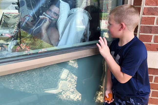 Sexårige Brody Barker vinkar till sin pappa Daryl, som vårdas för covid-19 på ett sjukhus i Missouri.