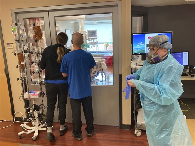 Två besökare tittar genom en glasruta in i en intensivvårdsenhet på ett sjukhus i Salem i Oregon i USA. Bilden är från den 20 augusti.