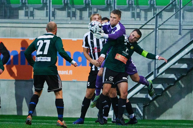 Antti Latva-Kivistö plockar åt sig bollen framför näsan på Sundom IF:s lagkapten Ludwig Siegfrids. VPS-målvaktens match tog slut efter att han slagit ena axeln ur led.