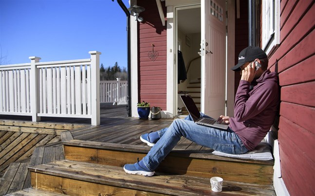 Med datorn på altanen. Färre av dem som jobbar hemma i Sverige sjukskriver sig.