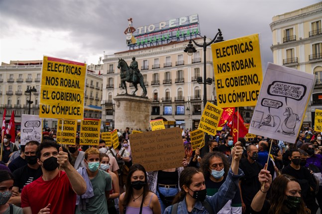 Protester i Madrid i somras mot höga elpriser: "Elbolagen rånar oss och regeringen är deras medbrottsling", står det bland annat på plakaten. Arkivbild.