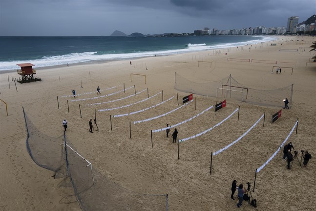 Vita näsdukar som symboliserar avlidna i covid-19 har hängts upp på stranden Copacabana i Rio de Janeiro.