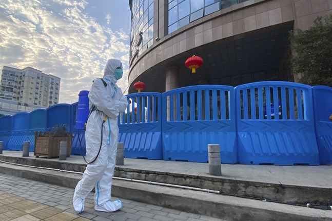 En person i skyddskläder utanför ett sjukhus i Wuhan i Kina. Nu gör WHO ett nytt försök att hitta coronavirusets ursprung. Arkivbild.