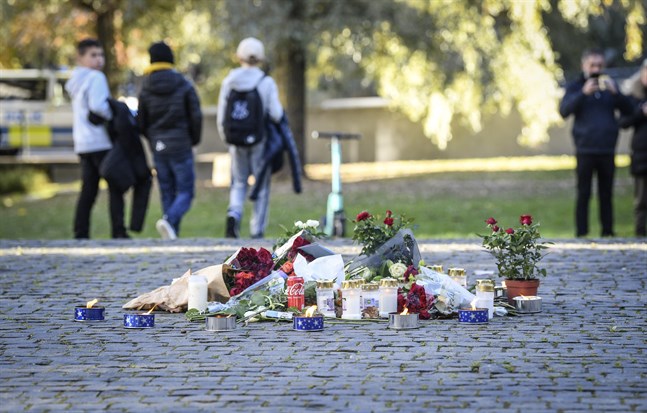 Tända ljus och blommor i närheten av platsen där artisten Einár sköts till döds i Hammarby sjöstad på torsdagskvällen.