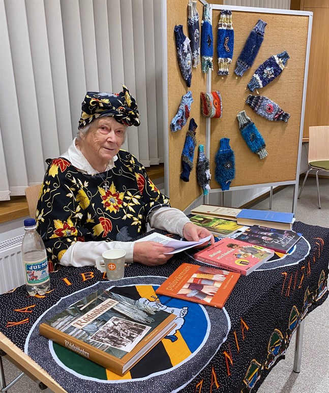 Greta Granbacka har under pandemin stickat och pyntat omkring 100 unika minnesmuffar, av vilka 50 nu finns utställda i Asta-salen på Nykarleby bibliotek.