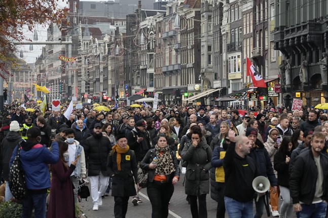 Människor demonstrerar i Amsterdam, trots att arrangörerna vädjat deltagare att stanna hemma efter de kaotiska protesterna i Rotterdam på fredagen.