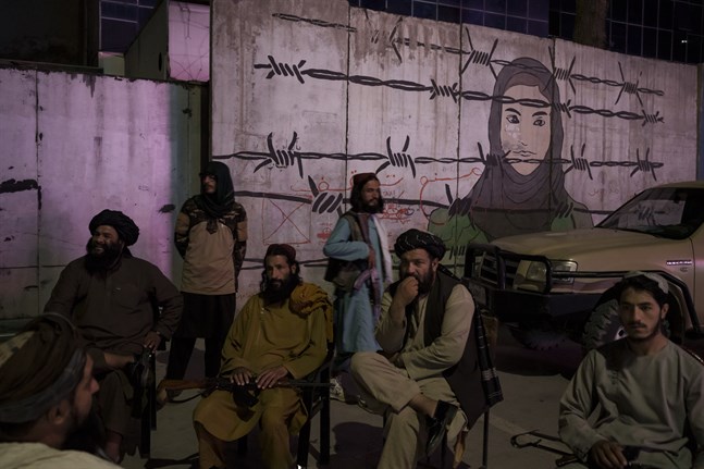 En grupp talibaner i samtal framför en väggmålning i Kabul. Arkivbild.