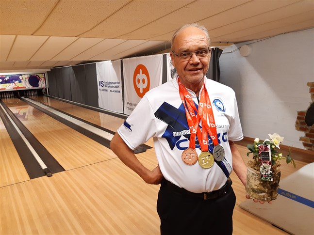 Leif Enfors med de tre VM-medaljerna från Dubai kring halsen och blomman som han uppvaktades med av IF Drott.