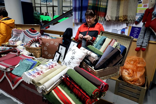 De som sökte mjuka julklappar fann många att välja mellan. Här stickar Inger Franzén bakom sina redan färdiga verk. – Jag har stickat, vävt, sytt och virkat till Kvinnornas julmässa i åtminstone tjugo år, säger Inger.