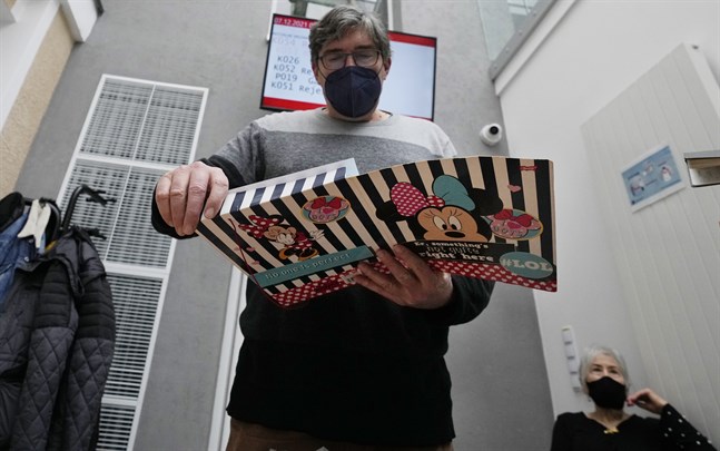 56-årige Andrzej Wiazecki i Warszawa lägger in sitt vaccinbevis i en mapp efter att ha fått tredje dosen häromdagen.