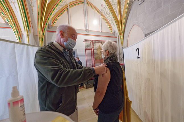 En kvinna vaccineras mot covid-19 i katedralen i Köln i Tyskland, som en del av en julvaccinationskampanj.