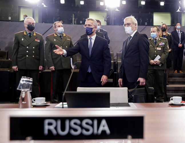 Natos generalsekreterare Jens Stoltenberg (mitten) visar Rysslands biträdande utrikesminister Aleksandr Grusjko och företrädare för det ryska försvarsdepartementet var de ska sitta vid onsdagens möte i Bryssel.