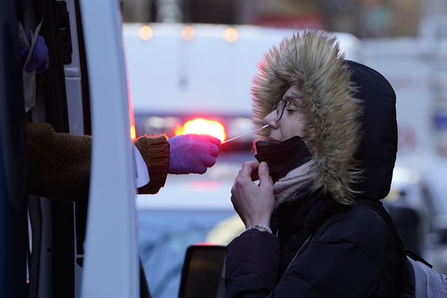 En kvinna testar sig för covid-19. Spridningen av omikronvarianten kan ha nått sin kulmen i Storbritannien, och snart även i USA.