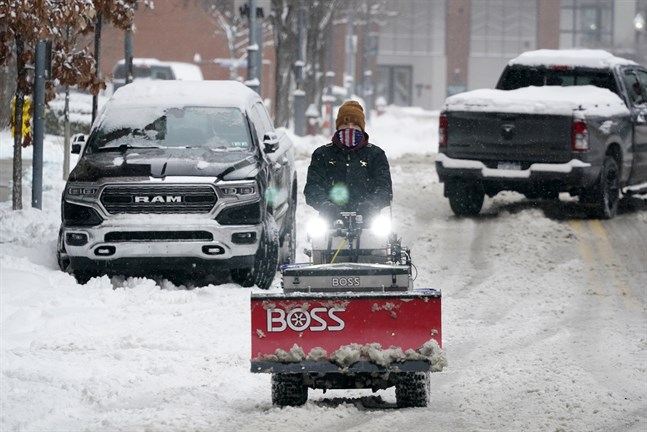 En man kommer farande med en snöplog i Pittsburgh under måndagen.