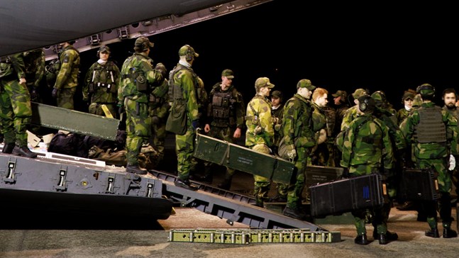 Militär enhet kliver av ett C-17-plan på flygplatsen i Visby på fredag kväll.