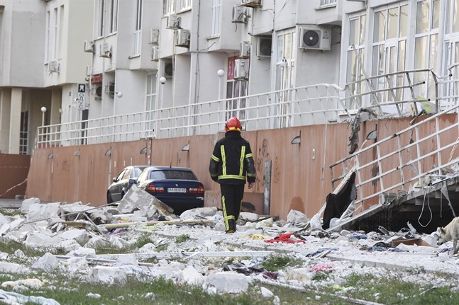 En räddningsarbetare passerar ett bostadshus i Odessa som förstördes av ryska raketattacker i lördags. Minst sex raketer avfyrades mot staden, enligt myndigheter i Ukraina.