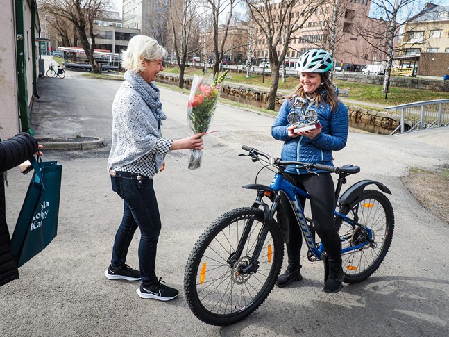 Lotta Nyqvist, Karleby stads idrottsdirektör, överräcker vandringspris och bukett till Årets cykelpendlare Nina Karhu.