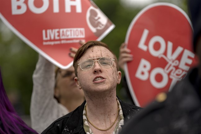 En man som demonstrerar mot aborträtten har fått chokladmjölk kastad på sig av demonstranter för abort i Washington.