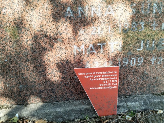 En röd skylt på graven berättar att skötselavtalet för all framtid inte längre är i kraft.