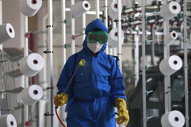 En anställd på en fabrik i Songyo-distriktet desinficerar arbetsgolvet i huvudstaden Pyongyang.