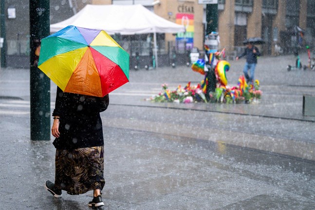 En kvinna går förbi den plats i Oslo där två människor miste livet och många skadades i en attack i midsommarhelgen.