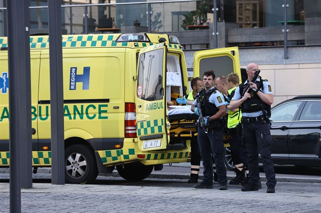 Polis på plats vid en ambulans utanför köpcentrumet.