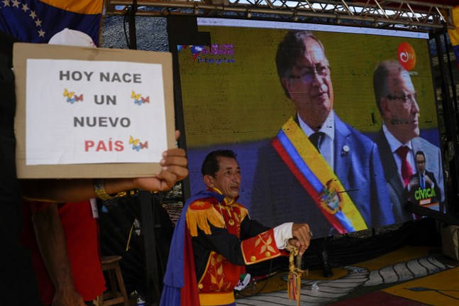 Anhängare till Gustavo Petro tittar på storbilds-tv när han svärs in som president.