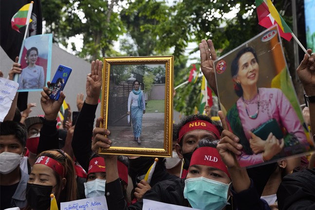 Myanmarier i Thailand håller upp bilder på den avsatta myanmariska ledaren Aung San Suu Kyi under en protest utanför Myanmars ambassad i Bangkok i juli.