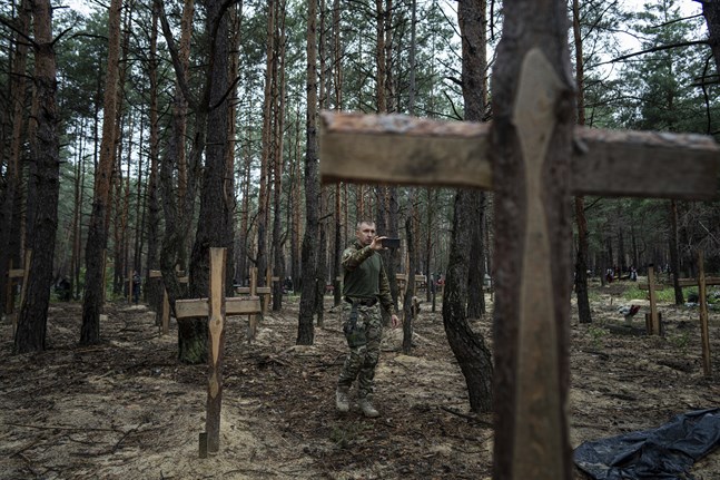 Gravplatsen utanför Izium med hundratalet gravar – många av dem märkta med bara ett nummer – dokumenteras av ukrainsk personal.