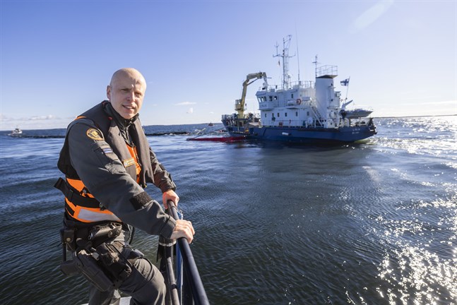 Arto Heinonen, äldre sjöbevakare, ledde operationen. I bakgrunden oljeuppsamlingsfartyget Linja.