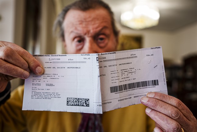 95-åriga Luigi Boni från Florens visar upp en räkning. Likt många italienare har han svårt att betala de allt dyrare räkningarna.